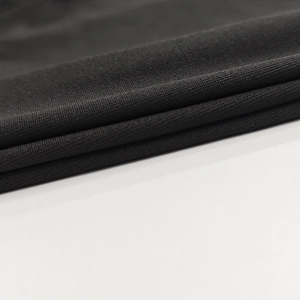 Vue macro du tissu en maille noire montrant la texture douce et les détails de tissage