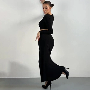 Side view of slim fit black long sleeve crop top and matching maxi skirt set