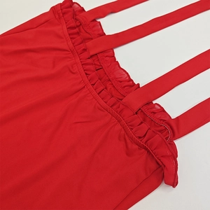 Detail of red bodycon dress featuring multi-strap design and ruffled texture fabric