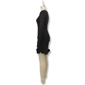 Detalle de vestido ajustado negro de manga larga con fruncidos y dobladillo con volantes