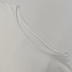 Primer plano de vestido blanco de cuello redondo con costuras finas y tejido suave