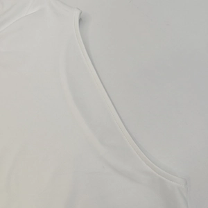 Detalle de las costuras planas precisas y la textura de la tela blanca de este vestido