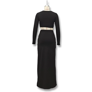 Rear view of sleek black two-piece set featuring long sleeve crop top and maxi skirt