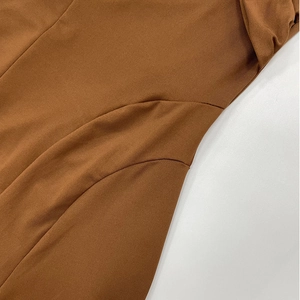 Gros plan sur la robe licou marron caramel montrant la maille côtelée et les coutures fines