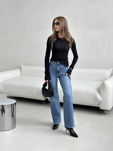 Slim fit black long sleeve top styled with light blue frayed hem jeans and black boots