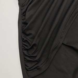 Detailed macro view of black ruched knit fabric with precise double-needle stitching
