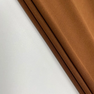 Gros plan sur le tissu en maille marron caramel montrant l'épaisseur et le drapé doux