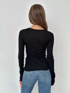 Rear view of slim fit black long sleeve top with flared sleeves and crew neck