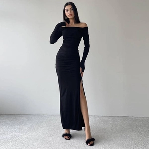 Détail d'une robe noire à épaules dénudées avec des fronces, fente haute et manches longues