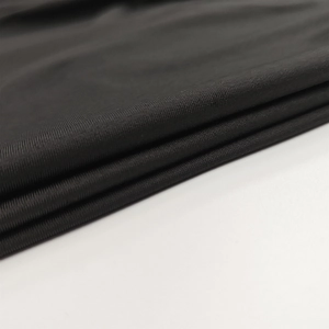 Close-up detail of high-quality black knitted fabric texture with fine matte finish