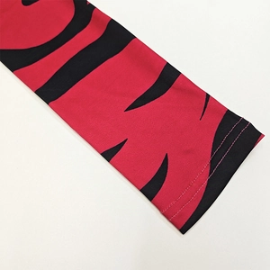 Nahaufnahme von rot-schwarzem Tigerstreifen-Muster am Langarmkleid mit Flachnaht-Detail