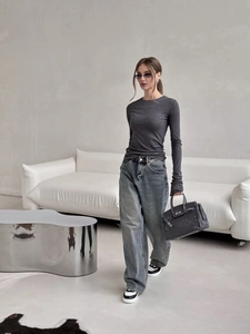 Detail of slim fit crew neck top with bell sleeves and high waist denim jeans
