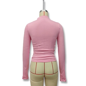 Detail view of pink long-sleeved turtleneck top with ruched elastic knit fabric from back
