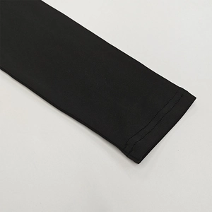 Gros plan détaillé sur la manchette à double couture d'un haut noir moulant très élastique