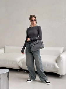 Detail showing a dark gray round neck knit top paired with high waist wide leg jeans