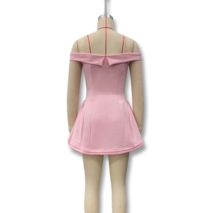 Detalle de minivestido rosa con hombros descubiertos, tirantes rojos y corte ajustado
