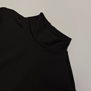 Detailed close-up of the black high-neck collar and smooth fabric texture of the dress