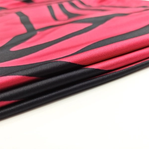 Makro-Detail des atmungsaktiven fuchsiafarbenen Stoffes mit schwarzem Muster am Kleid