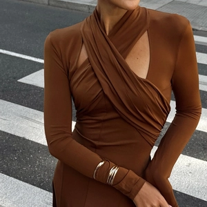 Robe longue moulante élégante marron caramel avec col croisé sur fond urbain