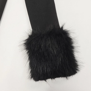 Détail rapproché de la robe noire avec une bordure en fausse fourrure sur la manche