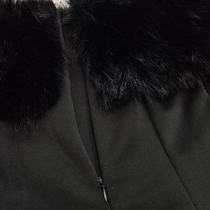 Détail d'une robe noire avec col en fausse fourrure et fermeture éclair invisible