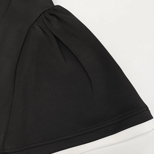 Detalle del vestido negro corto con forro blanco y dobladillo de costura doble de calidad