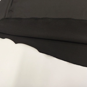 Detail of black knit fabric showing high-quality stitching and texture of the dress