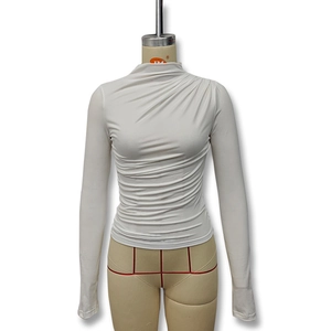 Detail of white slim fit long sleeve top featuring ruched sides and a stylish turtleneck