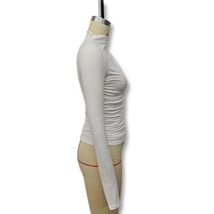 Close-up of white slim fit turtleneck top featuring side ruched pleated texture detail