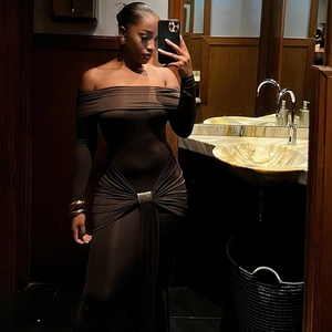 Detail view of the metal buckle and elegant ruching on a dark brown off-shoulder dress