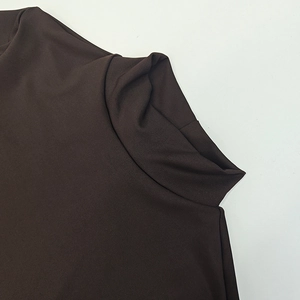 Detail of dark brown turtleneck knit dress with smooth texture and elastic fabric