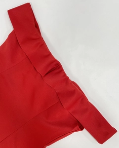 Detalle de escote con hombros descubiertos en vestido rojo ajustado con textura de tela