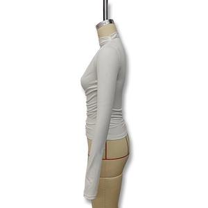 Detail view of white slim fit turtleneck top with stylish side ruched textures