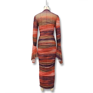 Detailed view of the artistic sunset gradient print and ruched fabric texture on dress