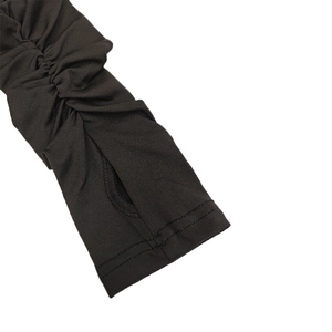 Gros plan détaillé sur manche en tricot noir avec design plissé et trou pour le pouce