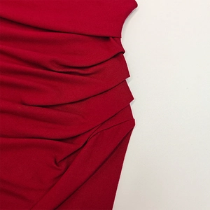 Close-up of elegant ruched detailing on a vibrant red slim-fit long sleeve shirt