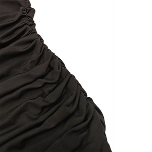 Vue macro des détails plissés du tissu tricoté extensible de la robe marron foncé