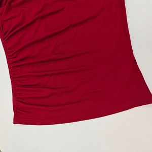 Detailed close-up of side ruching on a dark red long sleeve turtleneck top for women