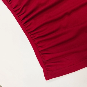 Detailed close-up of red ruched fabric with precise double-needle stitching and soft texture