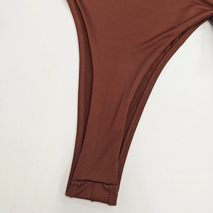 Détail d'un body marron rouille avec des coutures renforcées à double piqûre durables