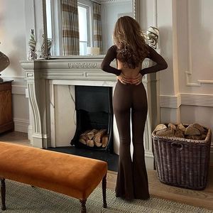 Detail view of the deep brown open back jumpsuit with slim fit long sleeves and flared legs
