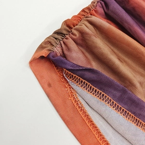 Detail of color-gradient mesh fabric with ruching and precise overlock stitching seams