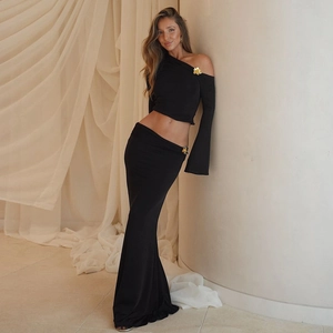 Detail of black two-piece set featuring golden floral buckles on shoulder and waist