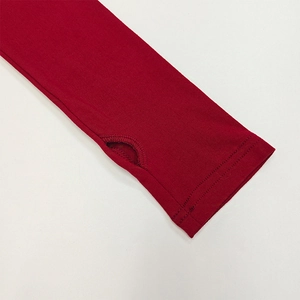 Detail of red long sleeve cuff featuring a thumbhole design and precise stitching