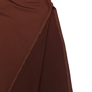 Détail de couture de la fente latérale sur une robe moulante marron foncé