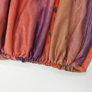 Detail of mesh fabric with colorful tie-dye patterns and ruched hem stitching