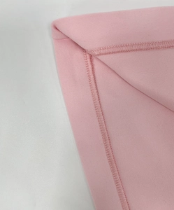 Primer plano del dobladillo rosa con costura de doble aguja en tela de algodón suave