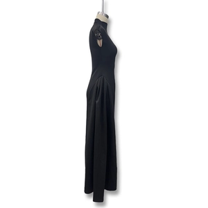 Detail of elegant black sleeveless gown featuring side pleated drapes and a chic stand collar