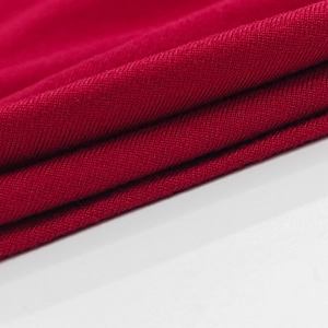 Close-up of red knitted fabric texture with fine stitching and soft ribbed details