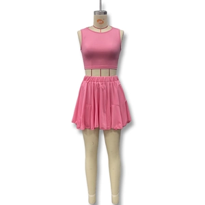 Detail view of pink two-piece set featuring a sleeveless crop top and pleated mini skirt